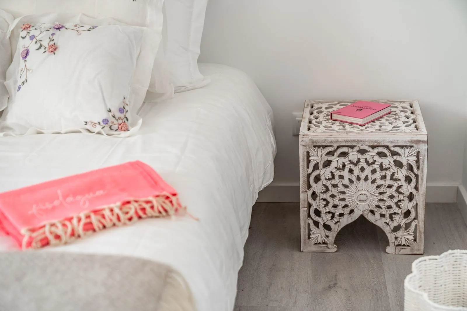 Bedroom detail with antique wooden high chair, fringe throw and wicker basket