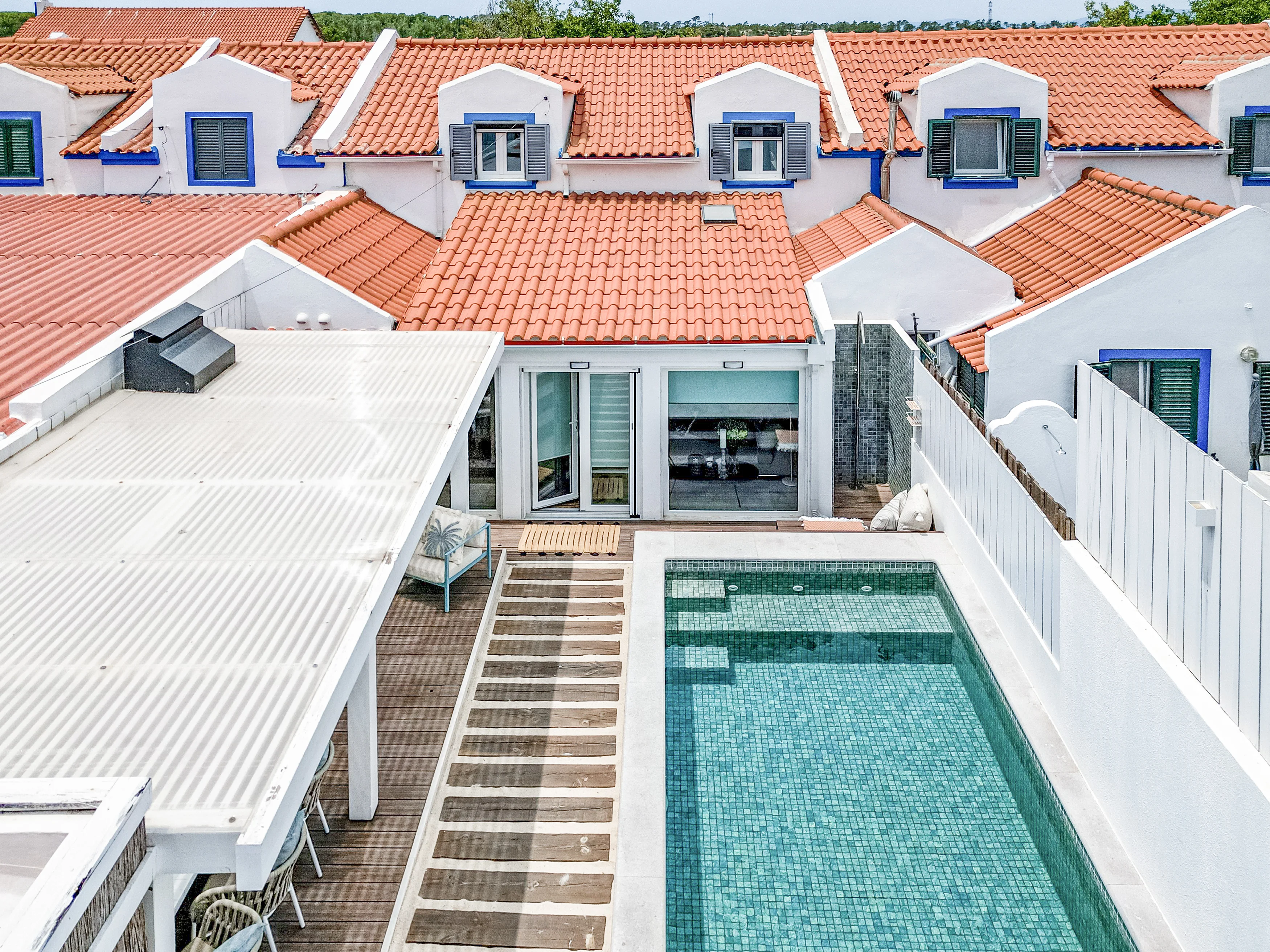 Aerial view of the courtyard with rectangular plunge pool, green mosaic tiles and wooden deck