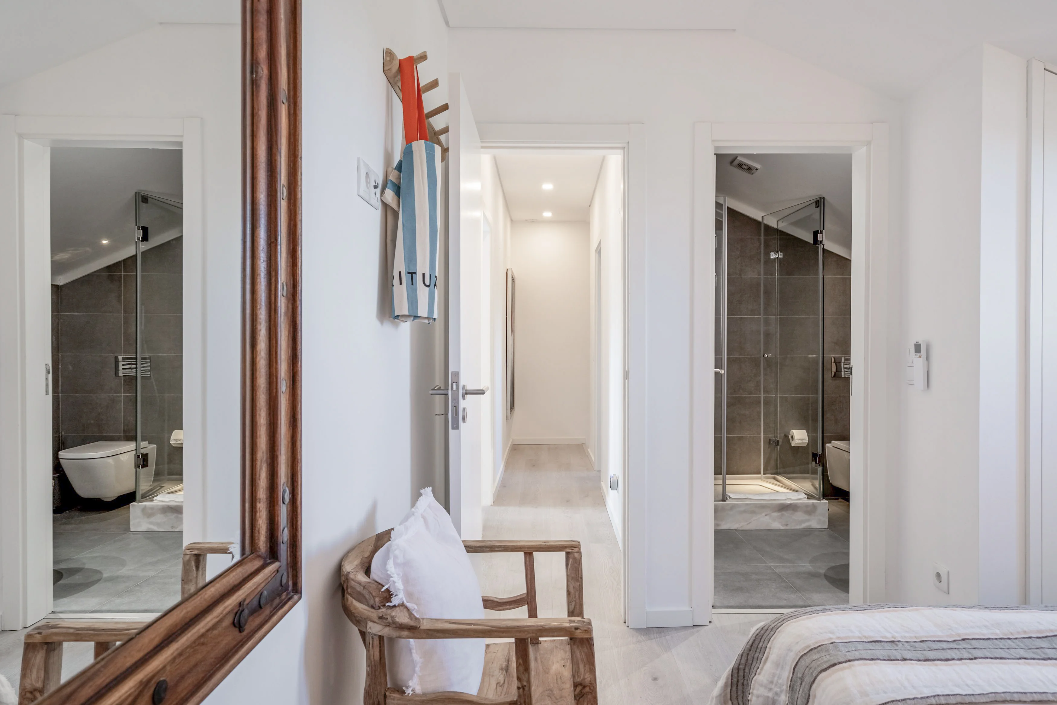 Bedroom suite hallway with two en-suite bathrooms and large rustic mirror