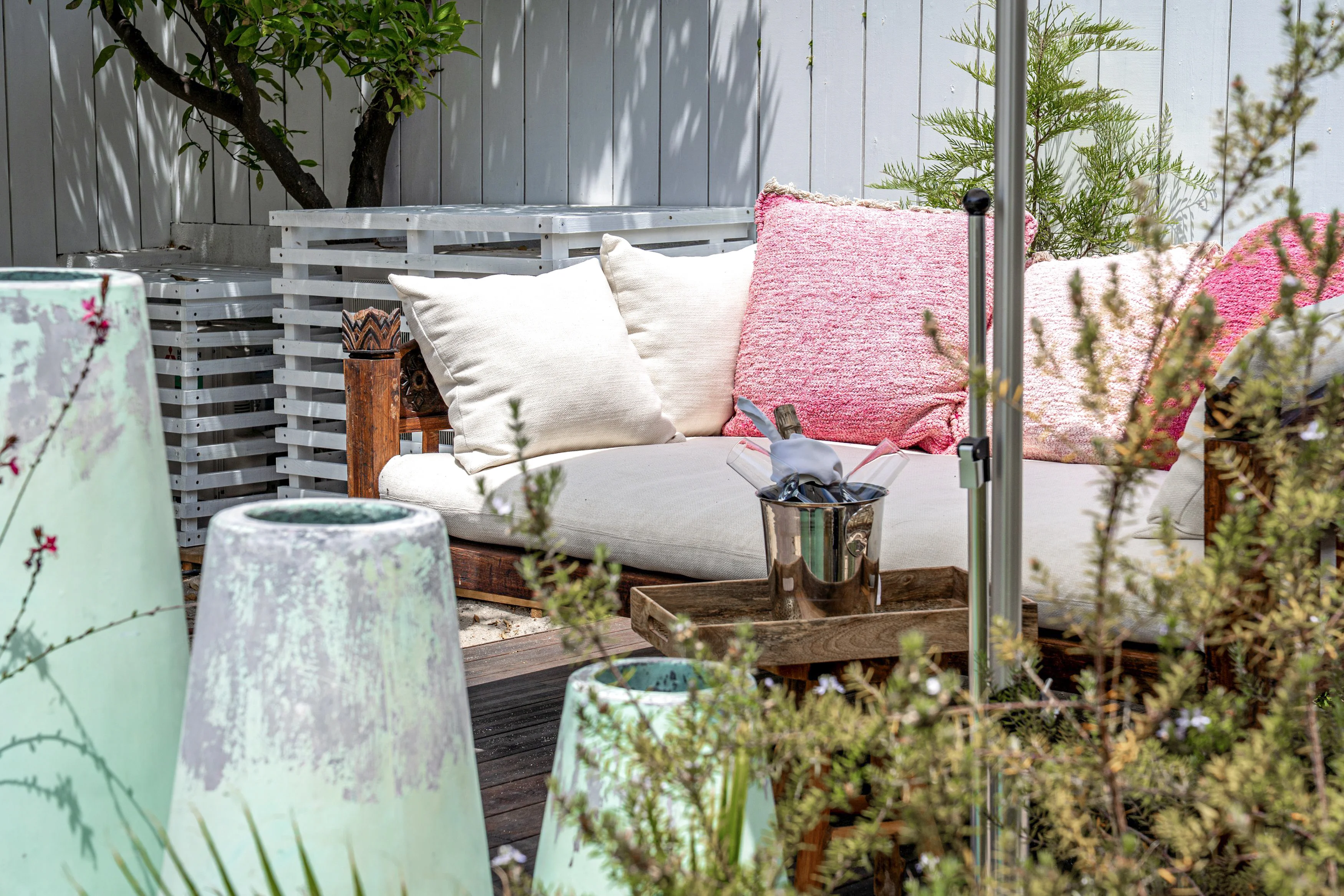Garden lounge with outdoor sofa, champagne bucket and mint-green ceramic lanterns