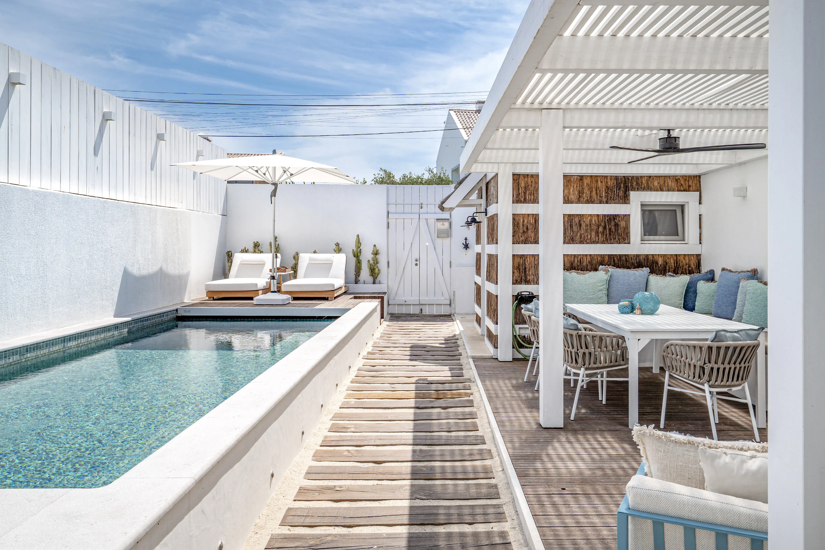 Poolside patio with thatched pergola, outdoor dining, sun loungers and outdoor shower