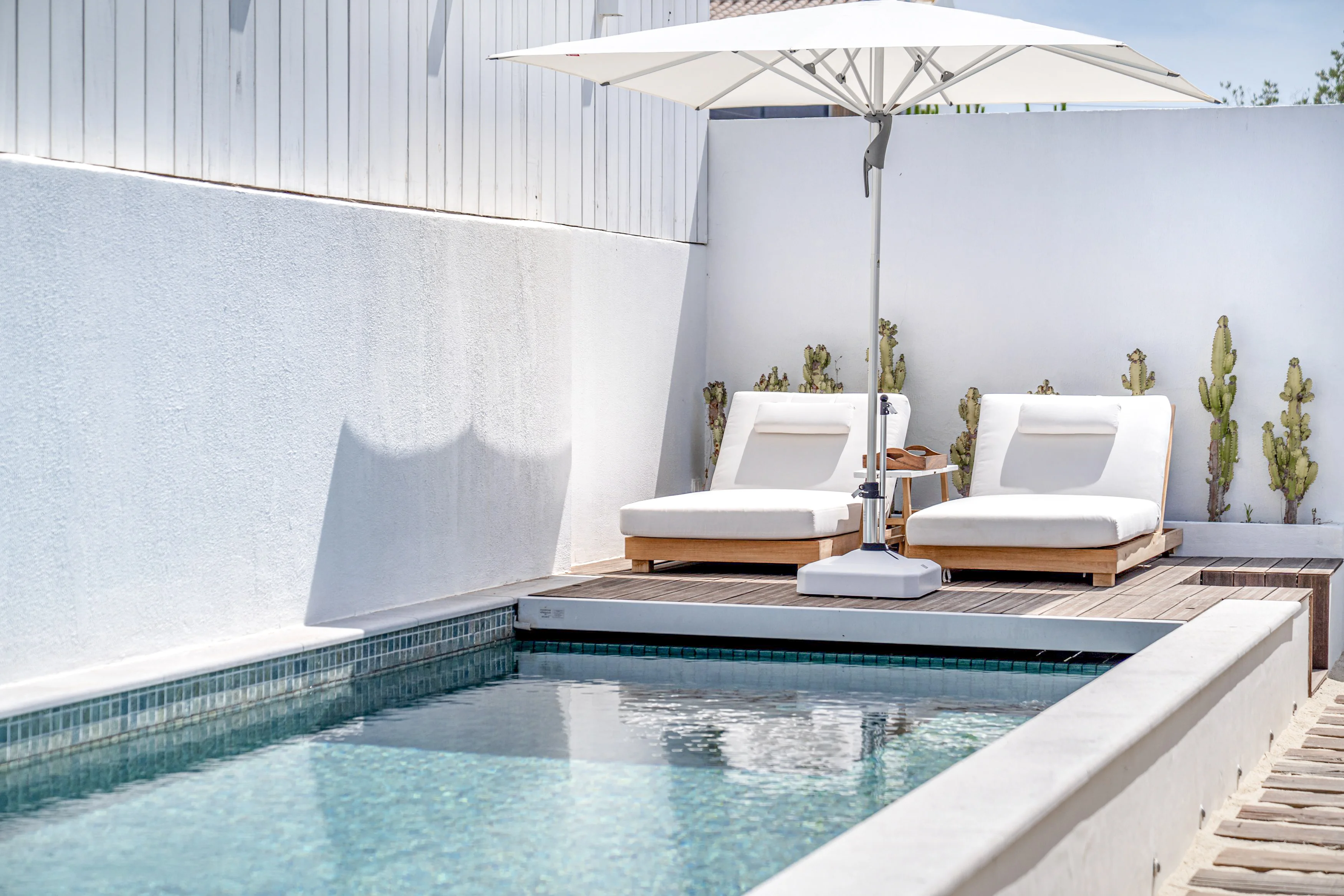 Poolside terrace with plunge pool, two sun loungers and cantilever umbrella